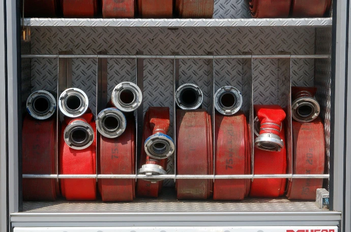 Opgerolde brandweerslangen met Storz koppelingen